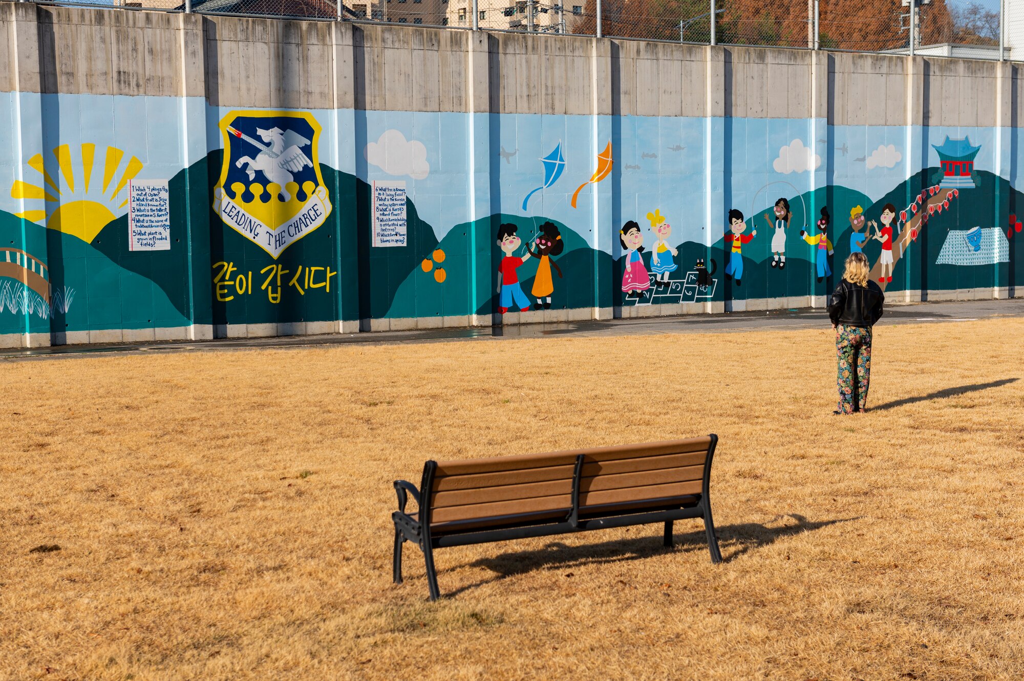 Tenley Brady, spouse of 1st Lt. Tre Brady, 303rd Intelligence Squadron flight commander and lead painter, admires a new mural located behind the commissary at Osan Air Base, Republic of Korea, Nov. 28, 2023. After working on the art piece for six months, Brady and volunteers completed the mural Nov. 19. The mural was completed in an effort to showcase appreciation for Korean culture. (U.S. Air Force photo by Senior Airman Kaitlin Castillo)