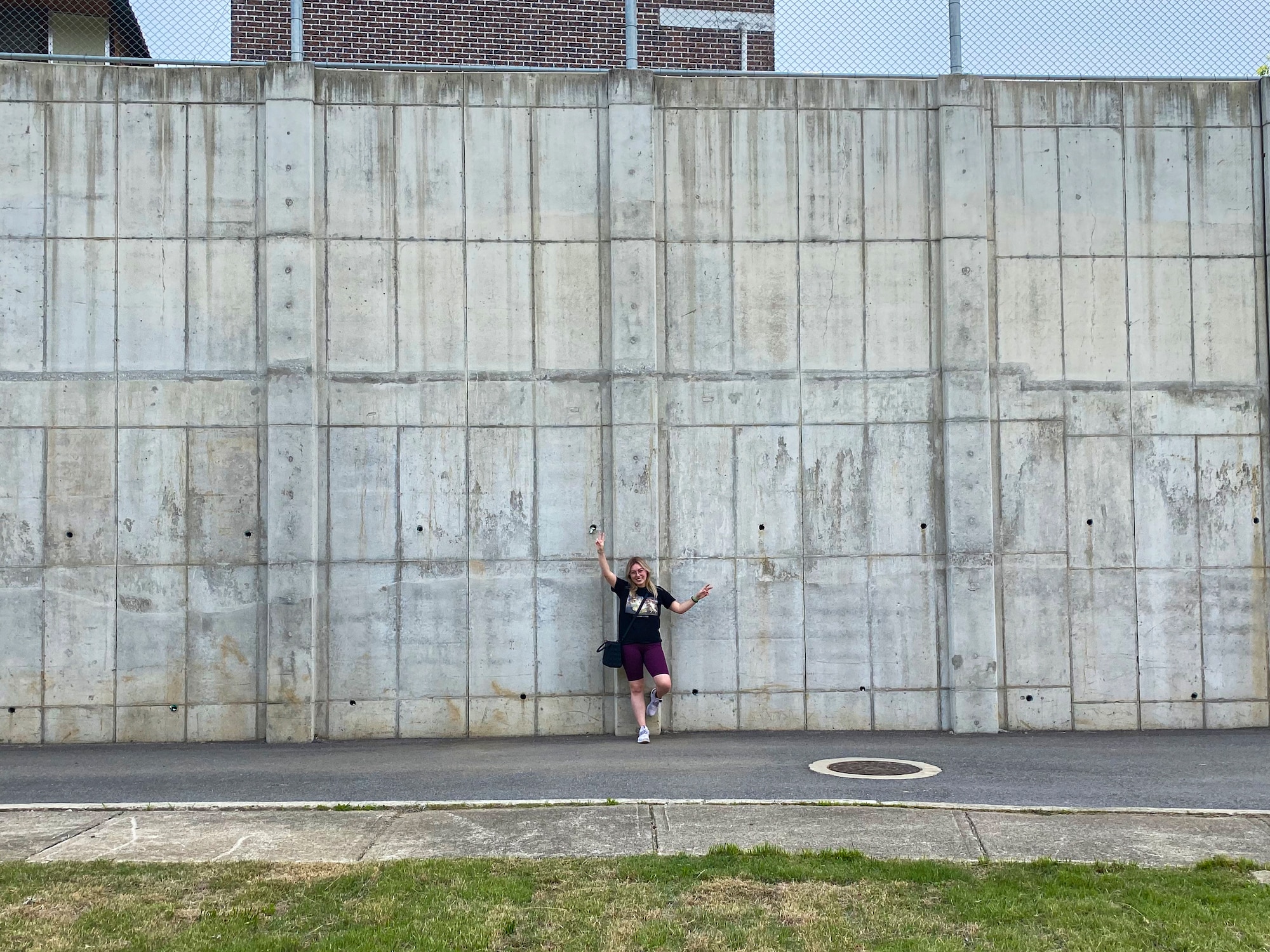 Tenley Brady, spouse of 1st Lt. Tre Brady, 303rd Intelligence Squadron flight commander and lead painter, stands in front of the blank wall prior to painting the mural at Osan Air Base, Republic of Korea, May 13, 2023. Brady hopes to spark joy and bring the community together to through a new mural. The mural was completed in an effort to showcase appreciation for Korean culture. (Courtesy photo)