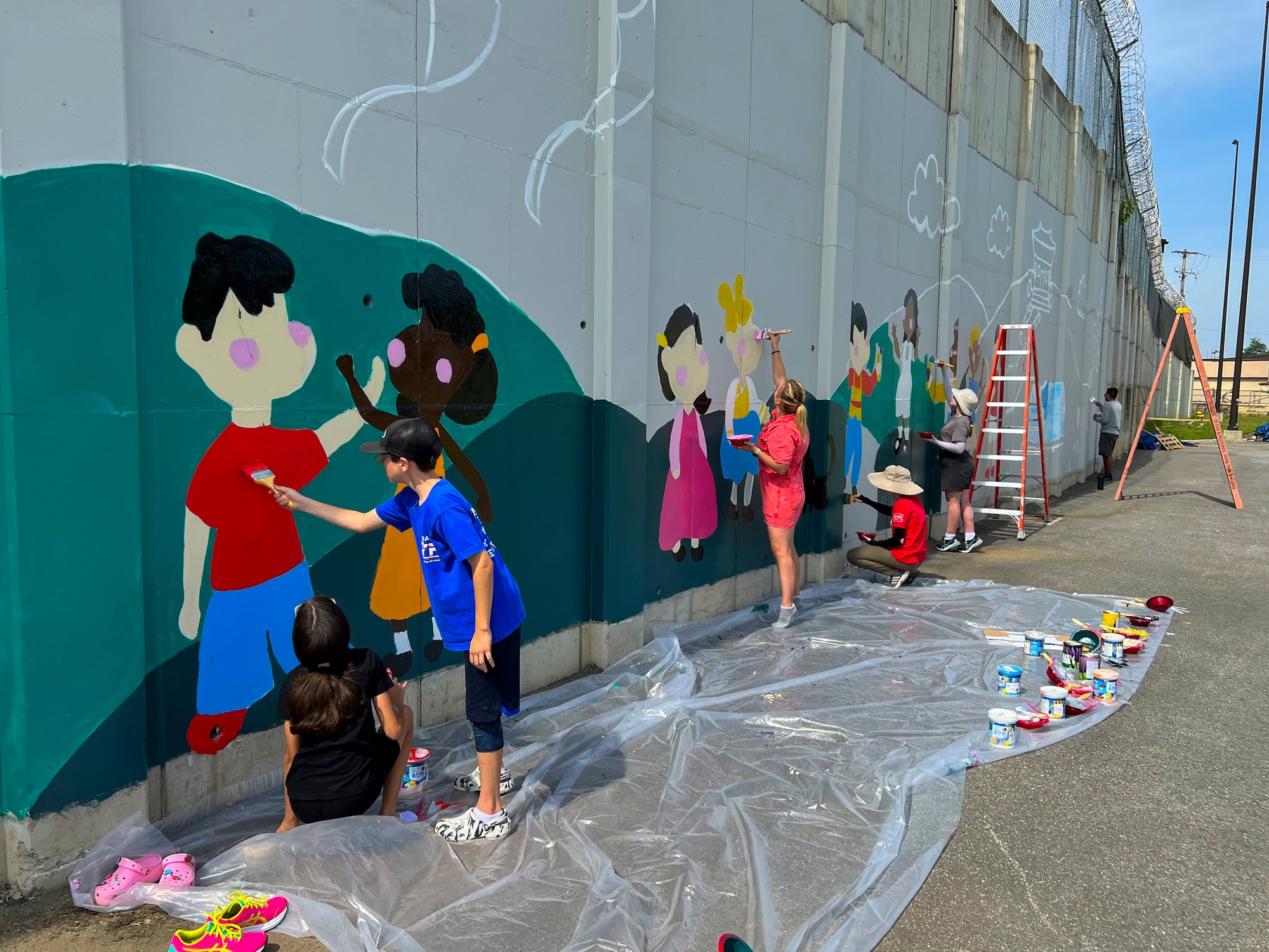 Military children help paint a new mural at Osan Air Base, Republic of Korea, Sept. 23, 2023. The mural highlights diversity, culture and the Osan community. (Courtesy photo)