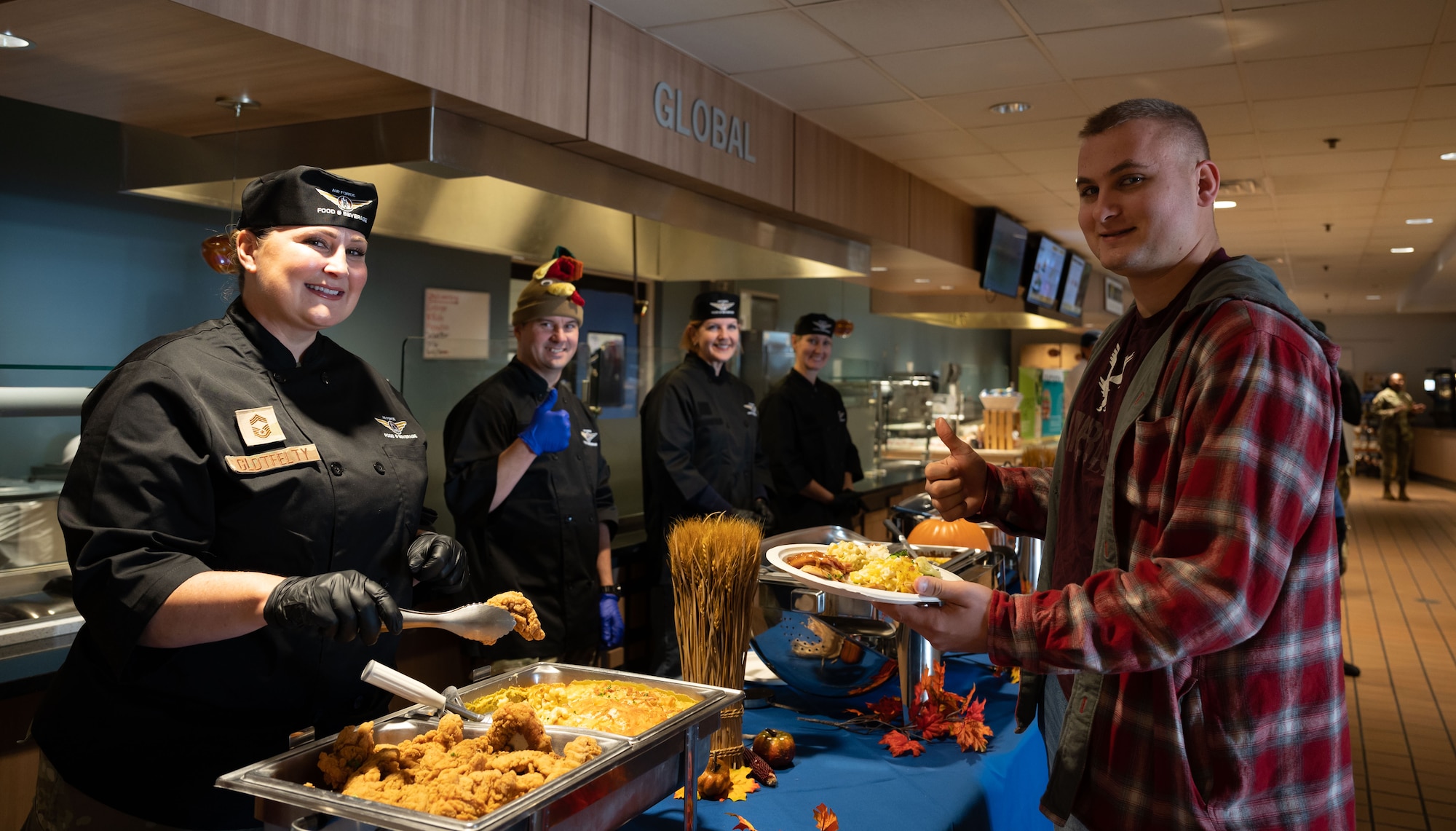 U.S. Air Force Chief Master Sgt. Janna Glotfelty, left, 436th Mission Support Group senior enlisted leader, poses with an Airmen during Thanksgiving lunch service at Dover Air Force Base, Delaware, Nov. 23, 2023. Team Dover members gathered together to share a Thanksgiving meal prepared by the Wright Patterson Dining Facility staff. (U.S. Air Force photo by Airman 1st Class Amanda Jett)
