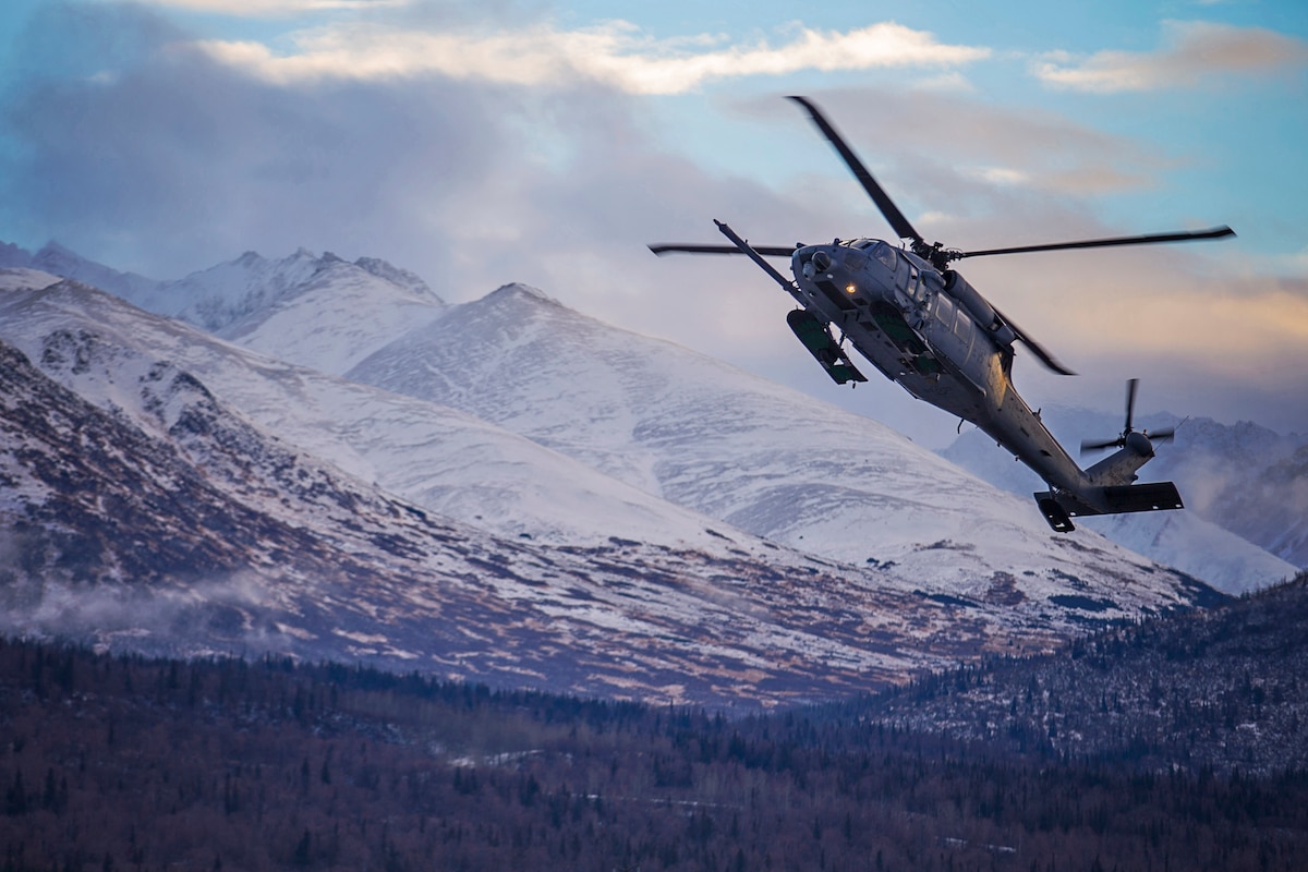 A 210th Rescue Squadron HH-60G Pave Hawk takes off at Joint Base Elmendorf-Richardson, Alaska. The Chugach Mountains provide the backdrop and were the site of a Nov. 16, 2023, rescue of an injured skier at the range’s Arctic Valley.
