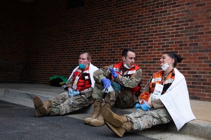 Joint Base Charleston Airmen participate in a medical exercise where they act as patients with simulated wounds. Medical Group staff wear protective hear as they treat the simulated patients.