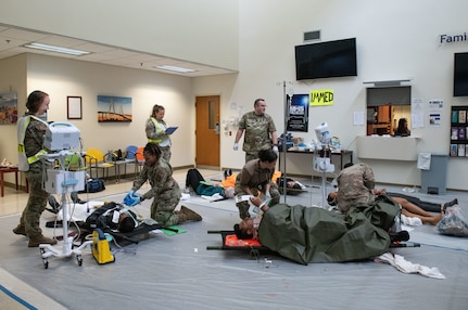 Joint Base Charleston Airmen participate in a medical exercise where they act as patients with simulated wounds. Medical Group staff wear protective hear as they treat the simulated patients.