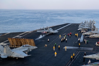 U.S. Navy Sailors participate in flight operations as an F/A-18E Super Hornet fighter jet, attached to the "Gunslingers" of Strike Fighter Squadron (VFA) 105, launches off the flight deck aboard the aircraft carrier USS Dwight D. Eisenhower (CVN 69) in the Gulf of Oman Nov. 24, 2023.