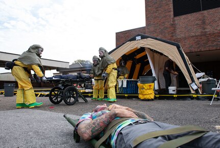 Joint Base Charleston Airmen participate in a medical exercise where they act as patients with simulated wounds. Medical Group staff wear protective hear as they treat the simulated patients.