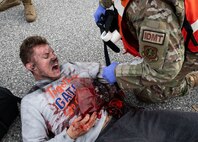 Joint Base Charleston Airmen participate in a medical exercise where they act as patients with simulated wounds. Medical Group staff wear protective hear as they treat the simulated patients.