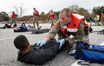 Joint Base Charleston Airmen participate in a medical exercise where they act as patients with simulated wounds. Medical Group staff wear protective hear as they treat the simulated patients.