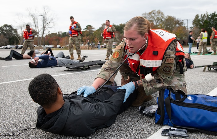 Joint Base Charleston Airmen participate in a medical exercise where they act as patients with simulated wounds. Medical Group staff wear protective hear as they treat the simulated patients.