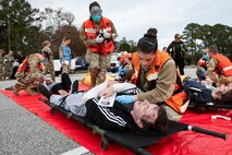 Joint Base Charleston Airmen participate in a medical exercise where they act as patients with simulated wounds. Medical Group staff wear protective hear as they treat the simulated patients.