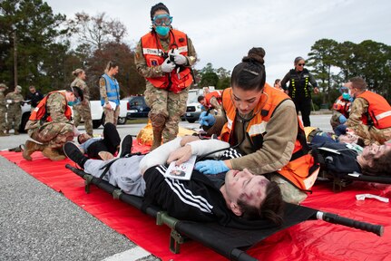 Joint Base Charleston Airmen participate in a medical exercise where they act as patients with simulated wounds. Medical Group staff wear protective hear as they treat the simulated patients.