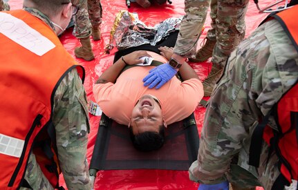 Joint Base Charleston Airmen participate in a medical exercise where they act as patients with simulated wounds. Medical Group staff wear protective hear as they treat the simulated patients.