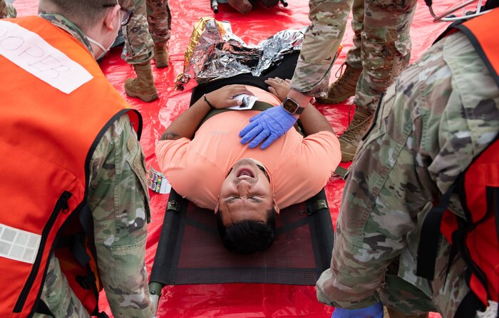 Joint Base Charleston Airmen participate in a medical exercise where they act as patients with simulated wounds. Medical Group staff wear protective hear as they treat the simulated patients.