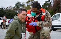 Joint Base Charleston Airmen participate in a medical exercise where they act as patients with simulated wounds. Medical Group staff wear protective hear as they treat the simulated patients.