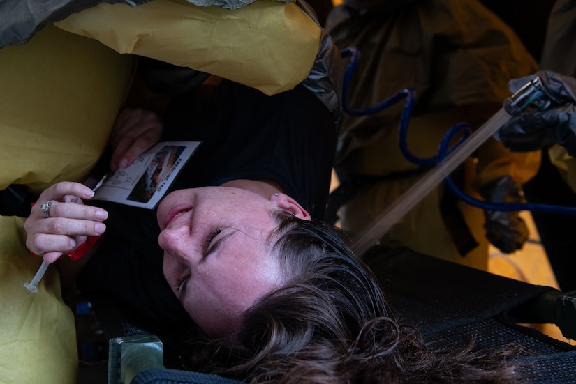 Joint Base Charleston Airmen participate in a medical exercise where they act as patients with simulated wounds. Medical Group staff wear protective hear as they treat the simulated patients.