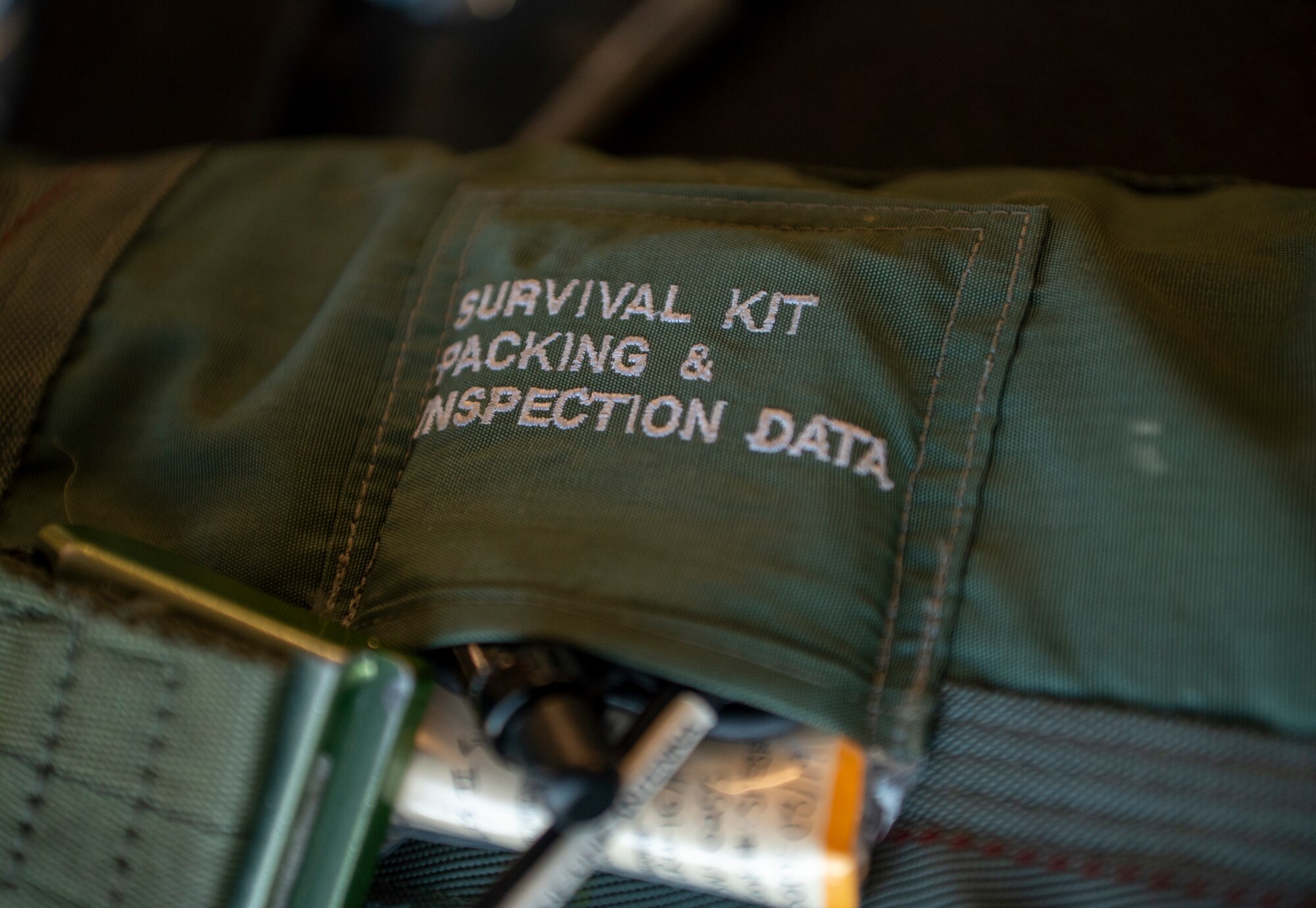 A packing list and inspection data packet rest inside a survival kit at Moody Air Force Base, Georgia, Nov. 20, 2023. A survival kit is an important part of an aircrew kit that gives pilots and aircrew vital life-saving equipment. (U.S. Air Force photo by Airman 1st Class Leonid Soubbotine)