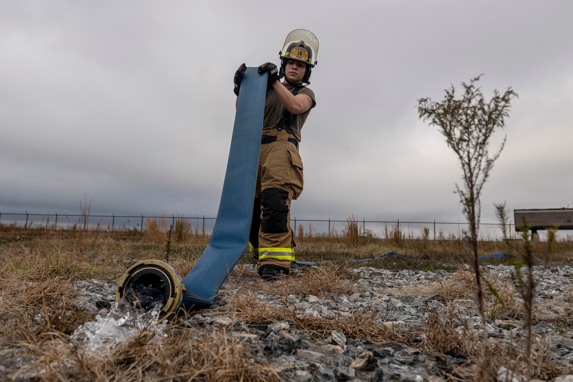 An Airman assigned to the 23rd Civil Engineer Squadron Fire Department drains water out of a hose
