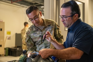 U.S. Space Force 1st Lt. Paolo Hora, 1st Range Operations Squadron range operations commander (left), and Jeffrey Barnes, 45th Logistics Readiness Squadron individual personnel equipment section lead (right), inspect a gas mask during a personnel deployment function line at Patrick Space Force Base, Florida, Oct. 5 2023. The 45th Logistics Readiness Squadron hosted its first PDF line, used to help streamline the pre-deployment process for service members, in more than 13 years. (U.S. Space Force photo by Airman 1st Class Spencer Contreras)