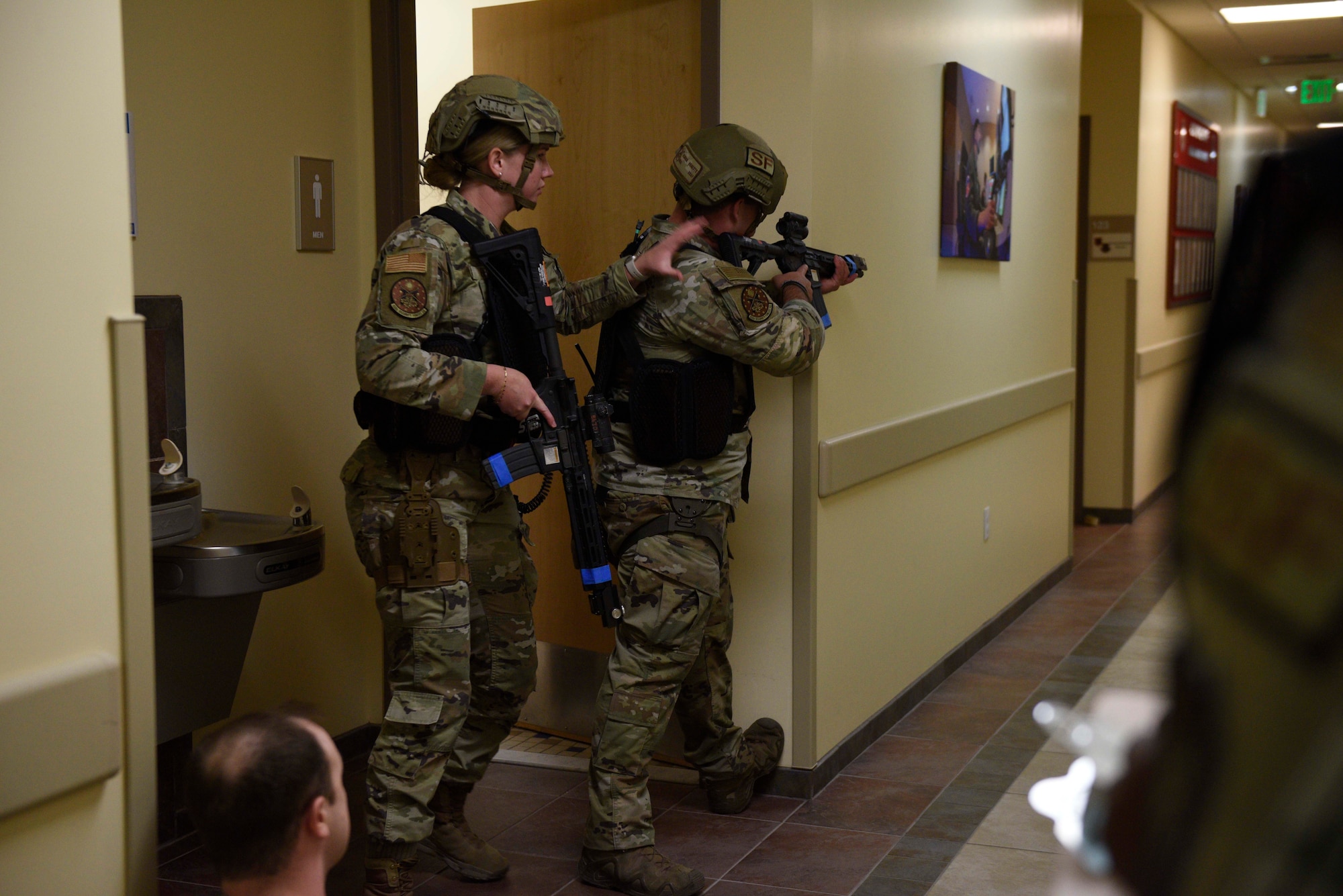 Two U.S. Air Force Airmen from the 432nd Security Forces Squadron participate in an active shooter exercise and begin to clear a hallway,