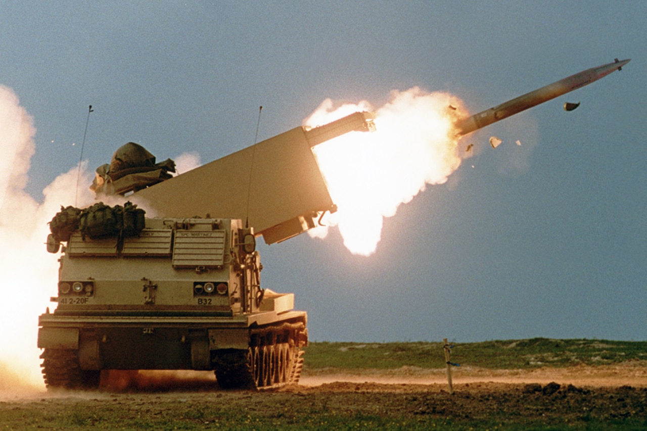 A large piece of military hardware mounted on a tracked vehicle launches a rocket.