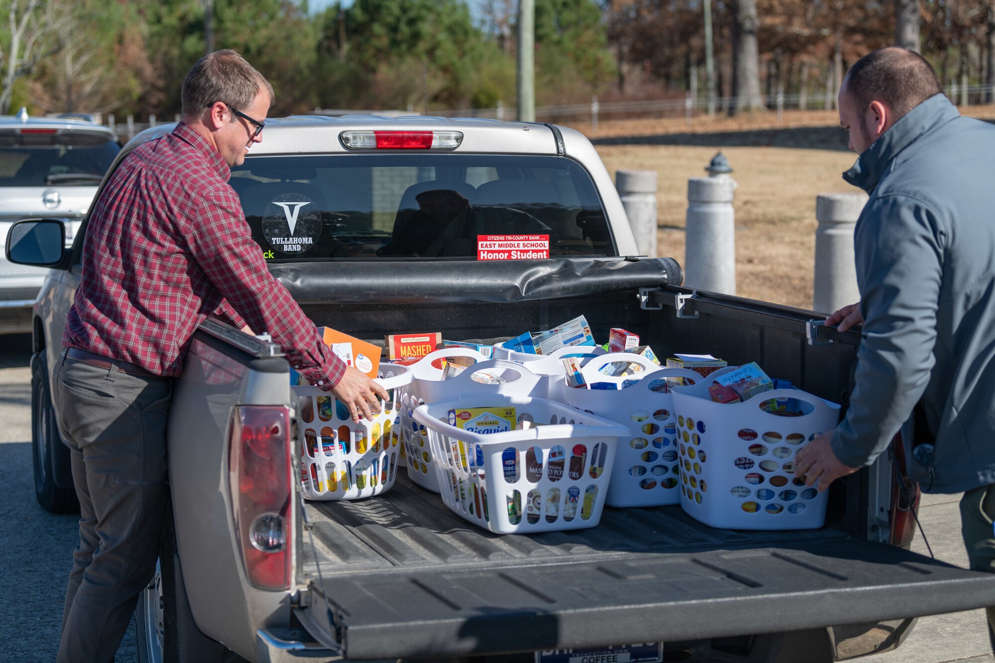 Arnold Air Force Base team members Joel Nalin, left, and Will Garner load food baskets assembled during the Arnold AFB Junior Force Council Thanksgiving Food Basket Drive for distribution Nov. 16, 2023, at Arnold AFB, Tenn. Throughout the drive, Arnold AFB team members donated nonperishable food items to be used for the baskets. This year, 57 baskets were provided for Coffee County families in need of food to prepare Thanksgiving meals. (U.S. Air Force photo by Keith Thornburgh)