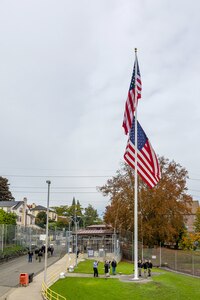 Members of a Puget Sound Naval Shipyard & Intermediate Maintenance Facility color guard raise a new American flag Nov. 9, 2023, during a special Veterans Day flag-replacement ceremony near the State Street Gate Entrance at PSNS & IMF in Bremerton, Wash. The event was hosted by the Veterans Employee Resource Group. (U.S. Navy photo by Jeb Fach)