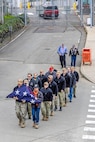 Members of a Puget Sound Naval Shipyard & Intermediate Maintenance Facility color guard carry the old American flag after it was replaced with a new flag Nov. 9, 2023, during a special Veterans Day flag-replacement ceremony near the State Street Gate Entrance at PSNS & IMF in Bremerton, Wash. (U.S. Navy photo by Jeb Fach)