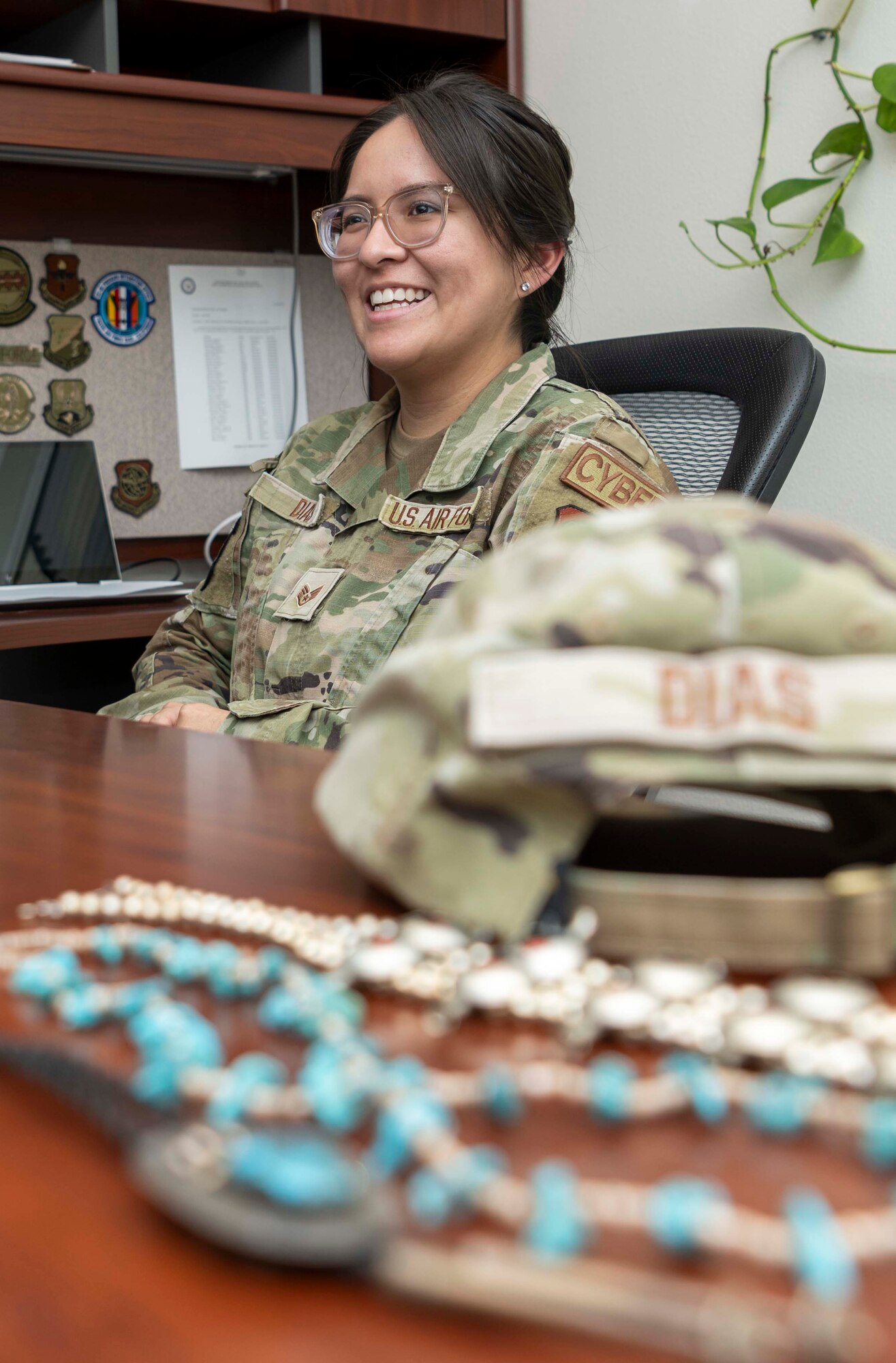 An Airman laughs at her workplace desk.