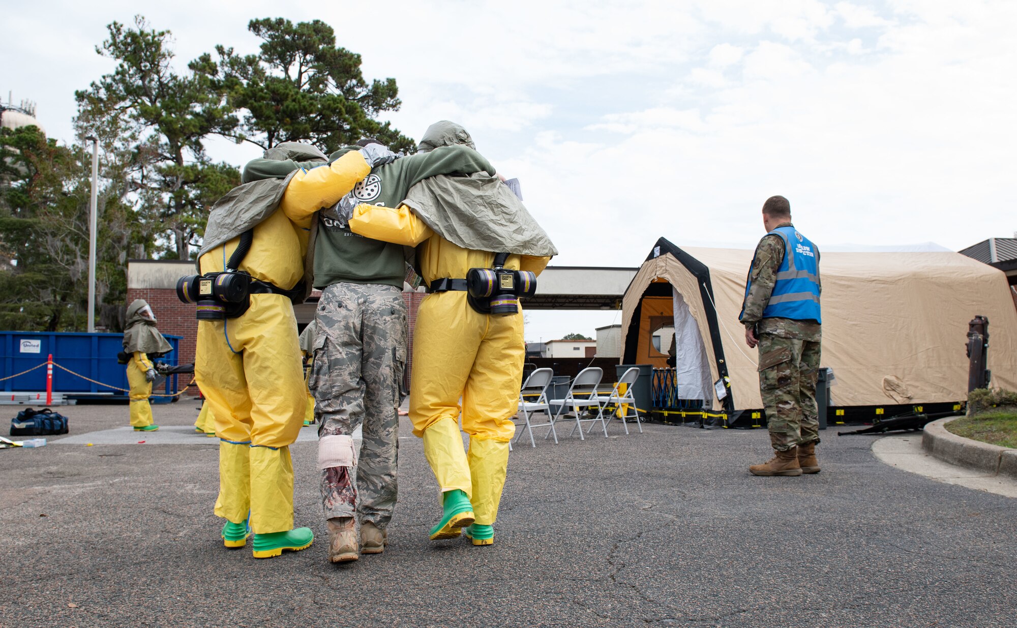 Joint Base Charleston Airmen participate in a medical exercise where they act as patients with simulated wounds. Medical Group staff wear protective hear as they treat the simulated patients.