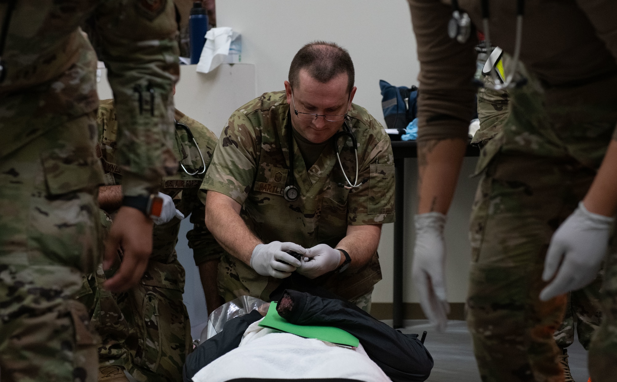 Joint Base Charleston Airmen participate in a medical exercise where they act as patients with simulated wounds. Medical Group staff wear protective hear as they treat the simulated patients.
