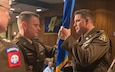 Brig. Gen. Christopher Schneider, Program Executive Officer Soldier, passes the organizational colors of Program Manager Soldier Lethality to the newly assigned Col. Jason Bohannon, PM SL, officially relinquishing authority from the outgoing officer Col. (RET) Scott Madore, 4 Aug. 2023 at Picatinny Arsenal, NJ. (Photo by Jesse Glass)