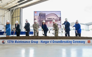 Eight people lined up with shovels, congressional and gubernatorial, Michigan National Guard and 127th Wing leaders.