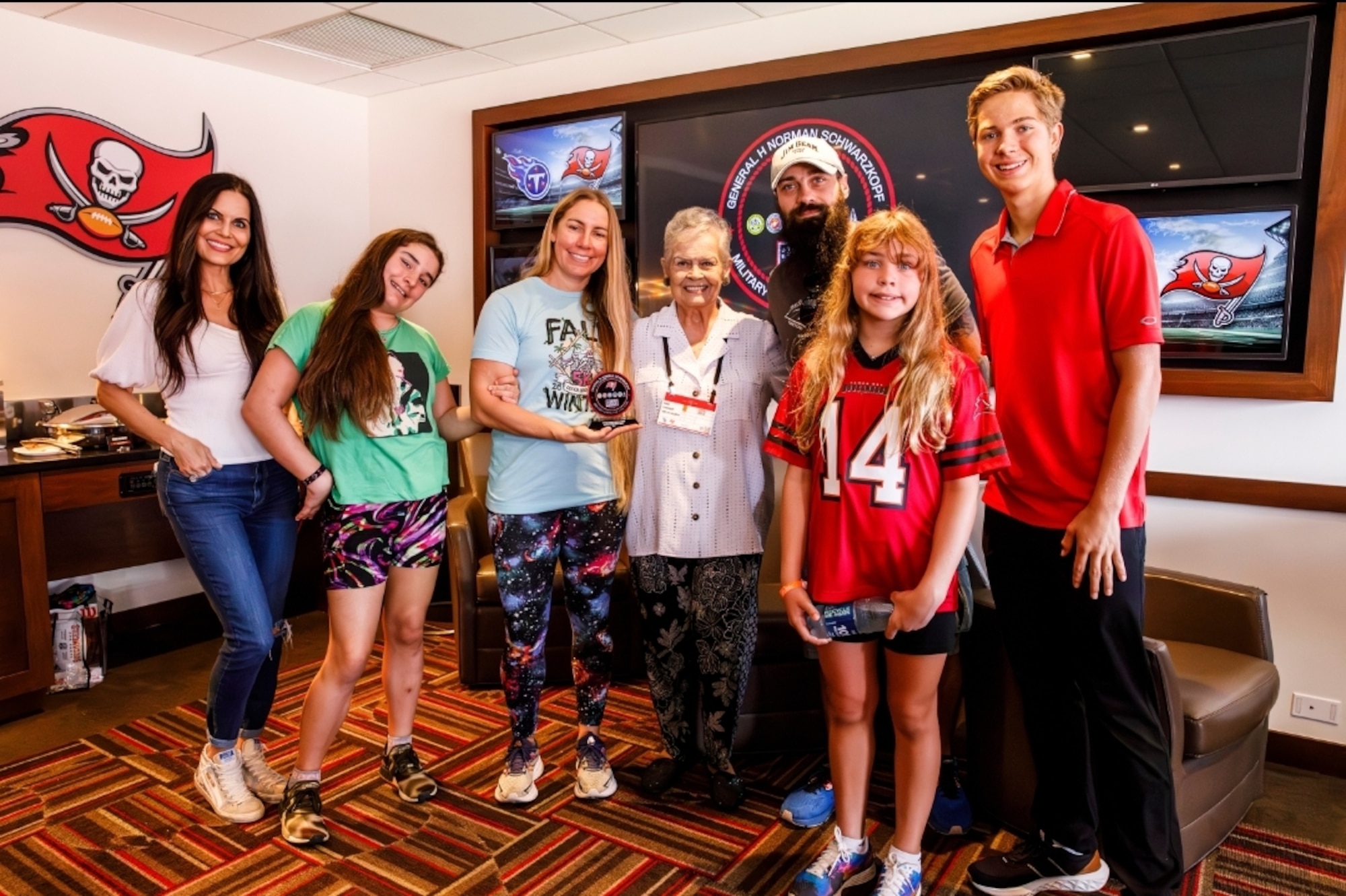 U.S. Space Force Capt. Tiffany Crick and her family pose with the family of late retired U.S. Army Gen. Norman Schwarzkop at the Salute to Service Suite in Raymond James Stadium in Tampa, Florida.