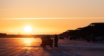 Crew chiefs from the 5th Aircraft Maintenance Squadron (AMXS) gather around a heater cart on the flight line to keep warm in freezing temperatures at Minot Air Force Base, North Dakota, Nov. 28, 2023. From landing to takeoff, crew chiefs assigned to the 5th AMXS ensure every aircraft is fully operational for its next flight. (U.S. Air Force photo by Airman 1st Class Alyssa Bankston)