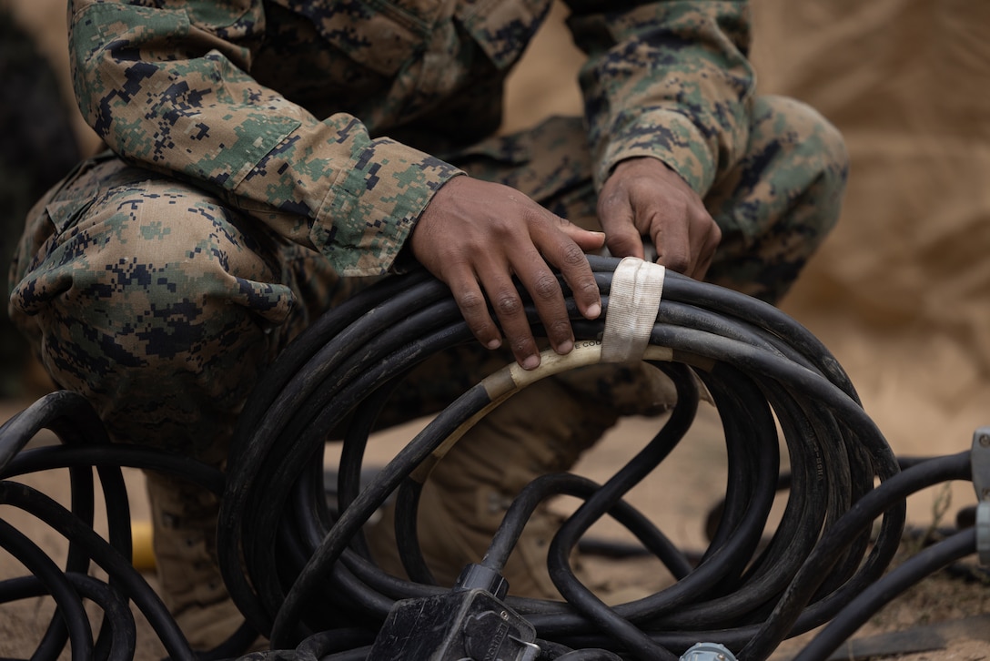 A U.S. Marine with Combat Service Support Company, I Marine Expeditionary Force Support Battalion, I MEF Information Group set up an outdoor power panel for combat tents in support of Exercise Steel Knight on Marine Corps Base Camp Pendleton, California, Nov. 29, 2023. Steel Knight 23.2 is a three-phase exercise designed to train I Marine Expeditionary Force in the planning, deployment and command and control of a joint force against a peer or near-peer adversary combat force and enhance existing live-fire and maneuver capabilities of the Marine Air-Ground Task Force. (U.S. Marine Corps photo by Lance Cpl. Tyler D. Wilson)
