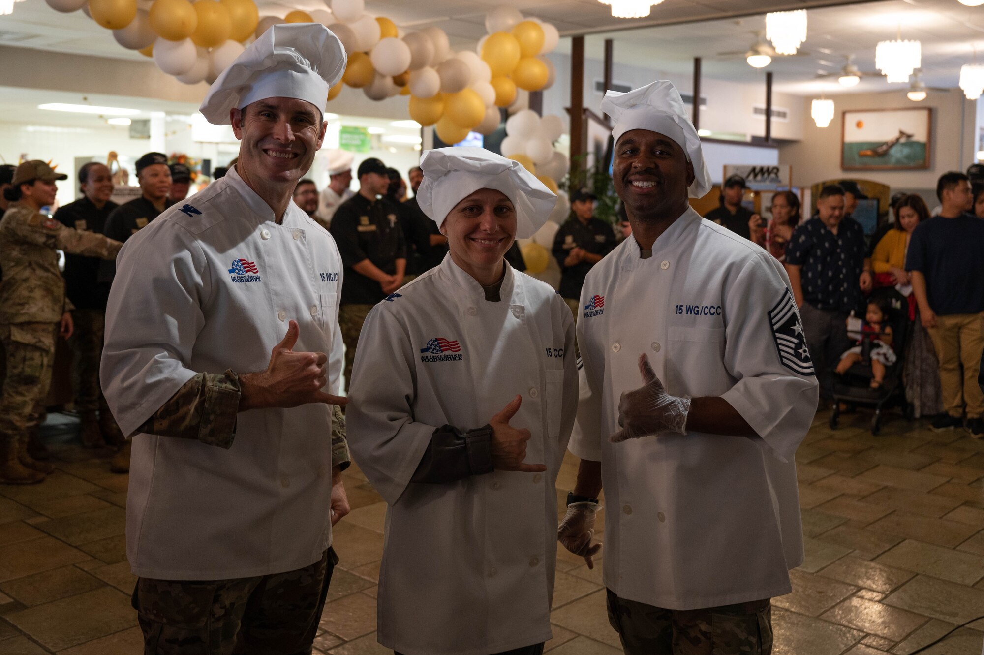 Col. Michele Lo Bianco, 15th Wing commander, Col. Keith Young, 15th Wing deputy commander, and Chief Master Sgt. Anthony Thompson Jr., 15th Wing command chief, pose for a photo before serving food to Airmen and their families at a Thanksgiving celebration at Joint Base Pearl Harbor-Hickam, November 23, 2023. Leaders from the 15th Wing showed their appreciation to Airmen and their families by serving them lunch on Thanksgiving. (U.S. Air Force photo by 2nd Lieutenant Margaret Blice)