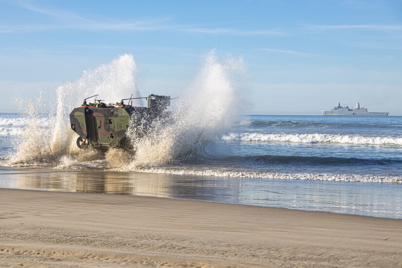 An amphibious combat vehicle splashes ashore.