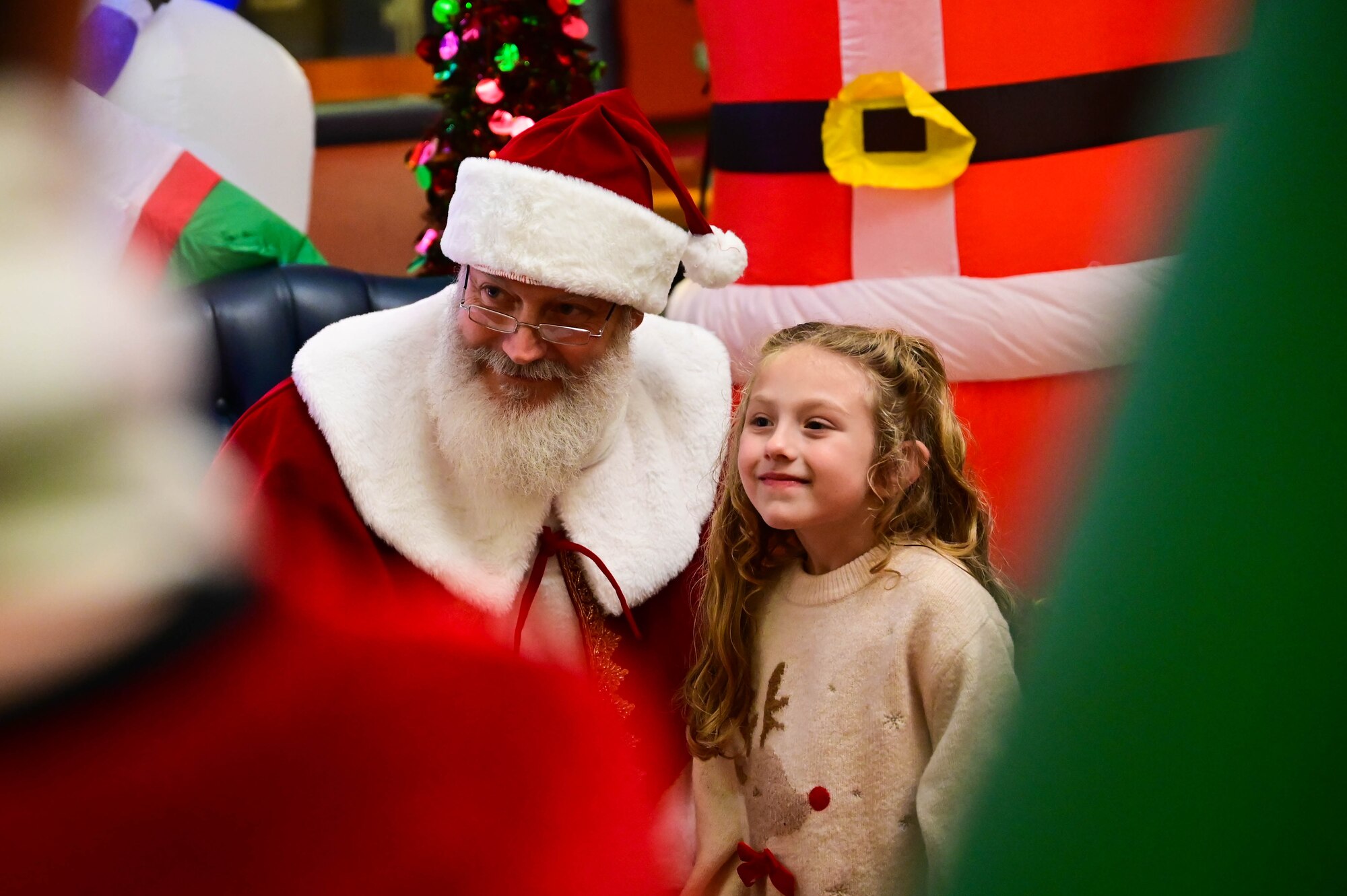Santa Claus takes photos with Airmen and their families during the annual Wyvern Wonderland.