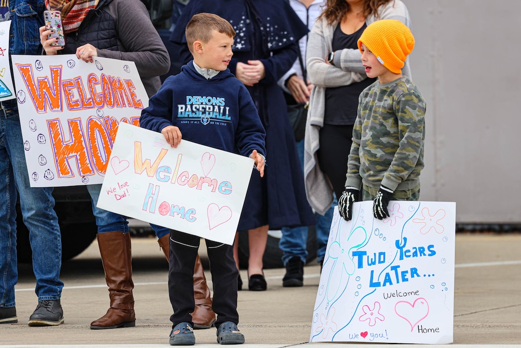 Two children holding signs and talking to each other.