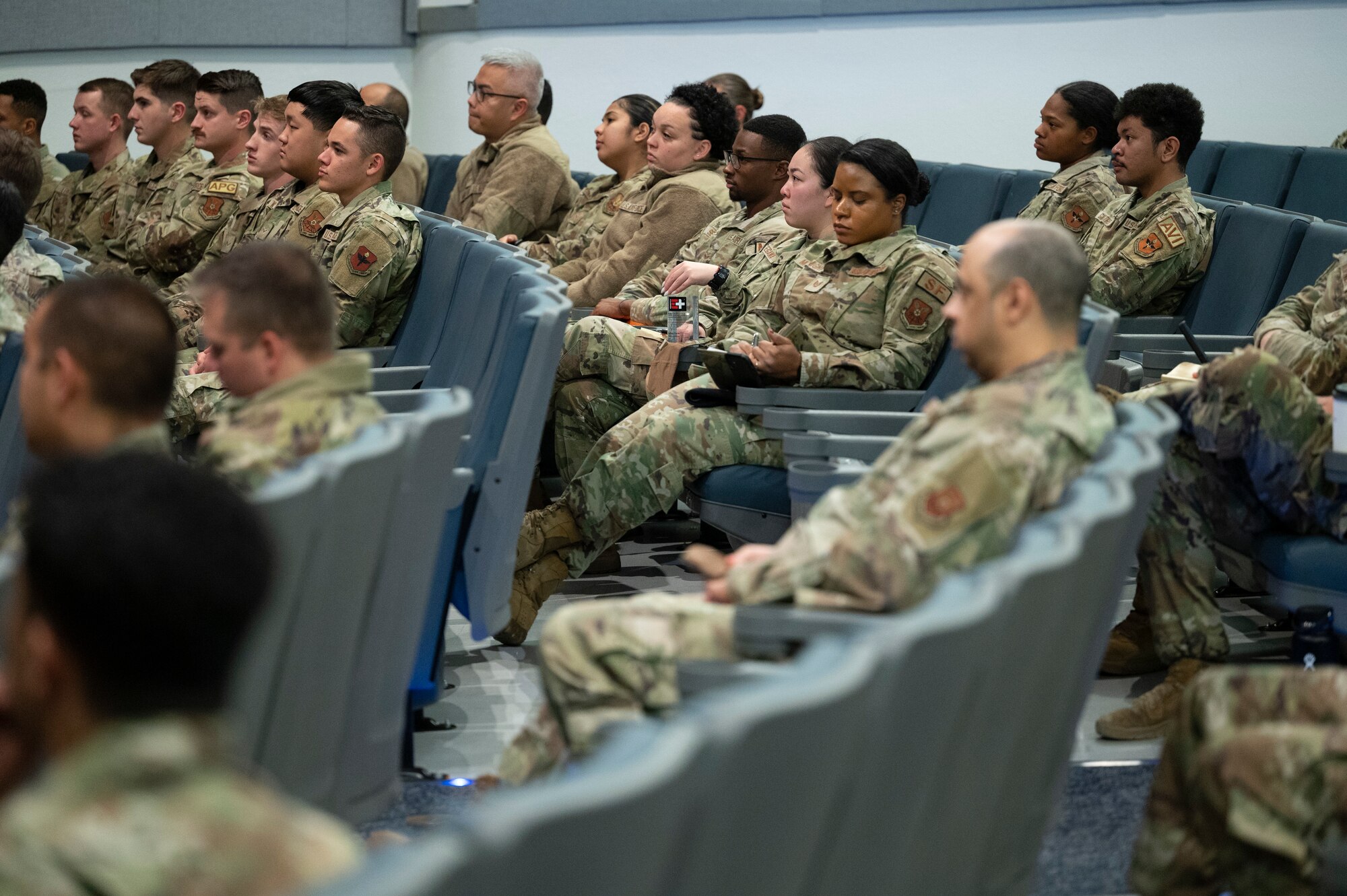 A group of people listen to a briefing.