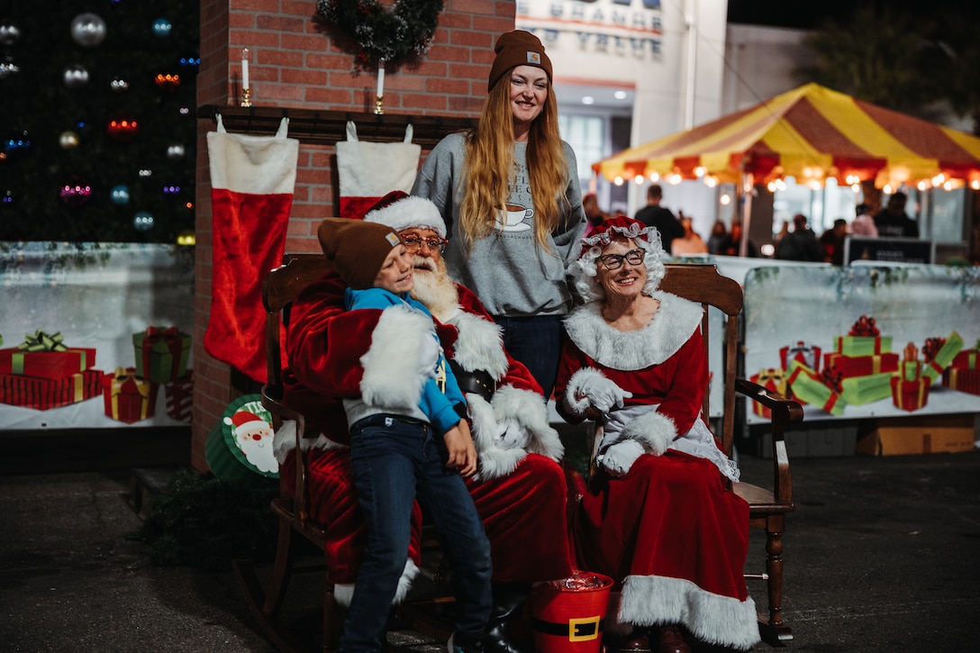 A mother and her child take a photo with Mr. and Mrs. Claus during the annual Christmas Tree Lighting Ceremony at Marine Corps Air-Ground Combat Center, Twentynine Palms, California, Nov. 17, 2023. The tree lighting ceremony is an annual event to kick off the holiday season with music, food, and fun to enhance the quality of life for the service members and DoD civilians of The Combat Center. (U.S. Marine Corps photo by Lance Cpl. Richard PerezGarcia)