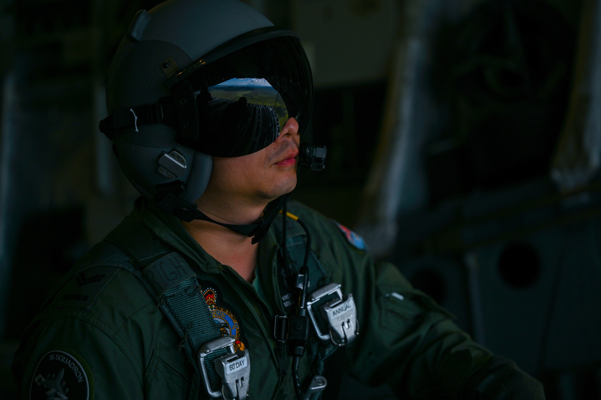 Royal Australian Air Force Cpl. Kristanto Sandjaja, No. 36 Squadron loadmaster, sits on the ramp of a C-17 Globemaster III during a training flight around the skies of Australia for Global Dexterity 23-2, Nov. 28, 2023. Exercise Global Dexterity prepares our air forces for combined action in wartime, peacetime and humanitarian operations throughout the Indo-Pacific. (U.S. Air Force photo by Senior Airman Makensie Cooper)