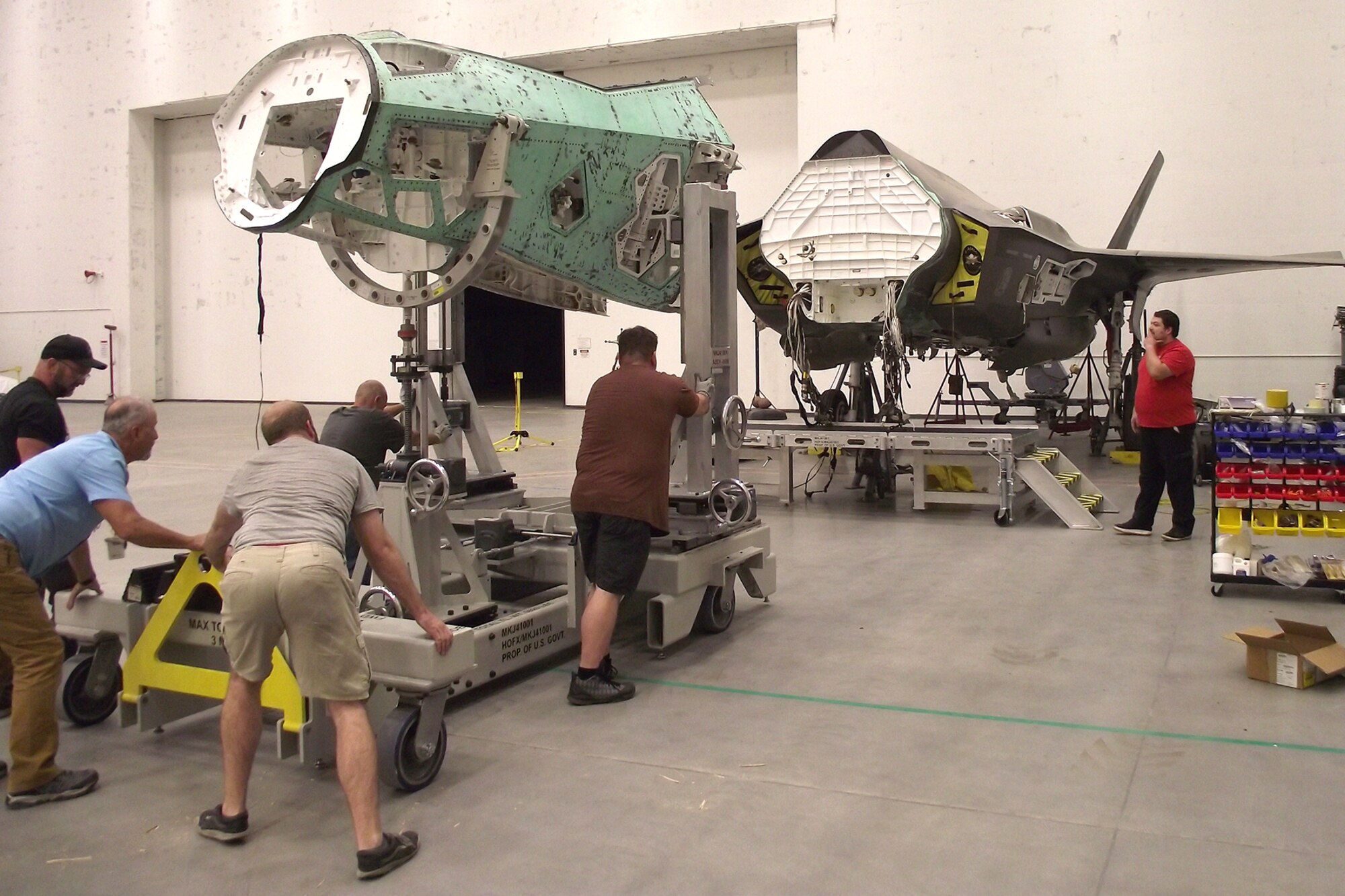 Personnel at Hill Air Force Base, Utah, reposition a salvaged nose section from an F-35 airframe using a new Mobil Maintenance System in October 2023. The MMS was created to de-mate and re-mate aircraft sections during a total reconstruction project of a wrecked F-35A Lightning II by the F-35 Joint Program Office. The project aims to restore the aircraft to full operational flying status. (U.S Air Force courtesy photo)