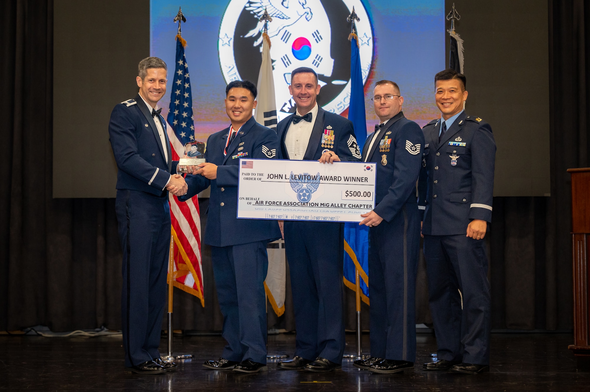 U.S. Air Force Staff Sgt. Johnny Ngo, 51st Munitions Squadron line delivery crew chief, receives the John Levitow Award during the Airman Leadership School class 23-E graduation ceremony at Osan Air Base, Republic of Korea, Sept. 29, 2023. The John Levitow Award is a prestigious honor presented to an outstanding graduate of ALS. This award recognizes the student who demonstrated excellence in leadership, academic performance, and personal attributes throughout the course. (U.S. Air Force photo by Staff Sgt. Thomas Sjoberg)