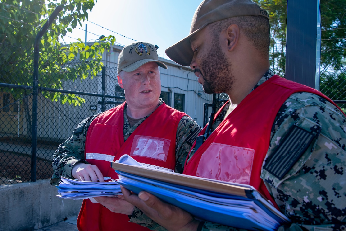 Master-at-Arms 1st Class Nicholas Gugliuzza and Operations Specialist 1st Class Johnny White, assigned to Naval Support Activity Souda Bay, Greece, discuss training plans during a Region Training Assist Visit onboard NSA Souda Bay on Sept. 21, 2023.