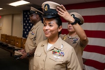 JACKSONVILLE, Fla. (Sept. 29, 2023) – Chief Navy Counselor Alejandrina Alonzo, assigned to Commander, Navy Region Southeast, receives her cover from her sponsor during a Chief Petty Officer pinning ceremony aboard Naval Air Station Jacksonville, Sept. 29, 2023. (U.S. Navy photo by Jacob Sippel/Released)