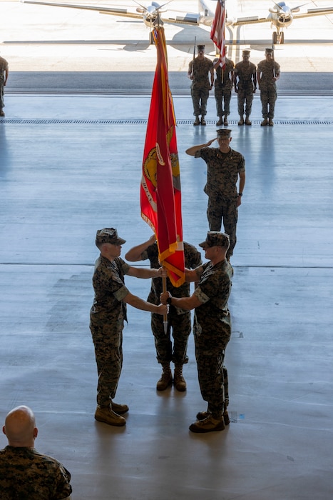Lt. Col. Sean P. Dillon exchanges the unit guide-on, which signifies the passing of command of Marine Transport Squadron (VMR) Belle Chasse, to Lt. Col. William T. Graves Jr. during their change of command ceremony at a VMR Hangar, Naval Air Station Joint Reserve Base, Belle Chasse, La. on June 2, 2023.