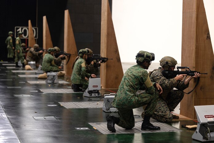 Singapore Army soldiers with 3rd Battalion Singapore Guards, 7th Singapore Infantry Brigade observe U.S. Marines with Marine Rotational Force-Southeast Asia (MRF-SEA), I Marine Expeditionary Force, fire Singaporean Assault Rifle 21 service rifles on a 100-meter range during Exercise Valiant Mark 2022 at the Multi-Mission Range Complex on Pasir Laba Camp, Singapore, Dec. 2, 2022. Valiant Mark is an annual, bilateral training exercise designed to enhance interoperability, build mutual defense capabilities, and strengthen military-to-military relationships between the U.S. Marine Corps and Singapore Armed Forces. MRF-SEA is an operational model developed by Marine Corps Forces Pacific that postures scalable I Marine Expeditionary Forces west of the International Date Line, conducts a series of planned subject matter experts exchanges, and advances security objectives shared with our Allies and Partners.