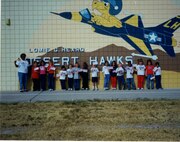 Class picture while holding flags at the school mural, class and date unknown.