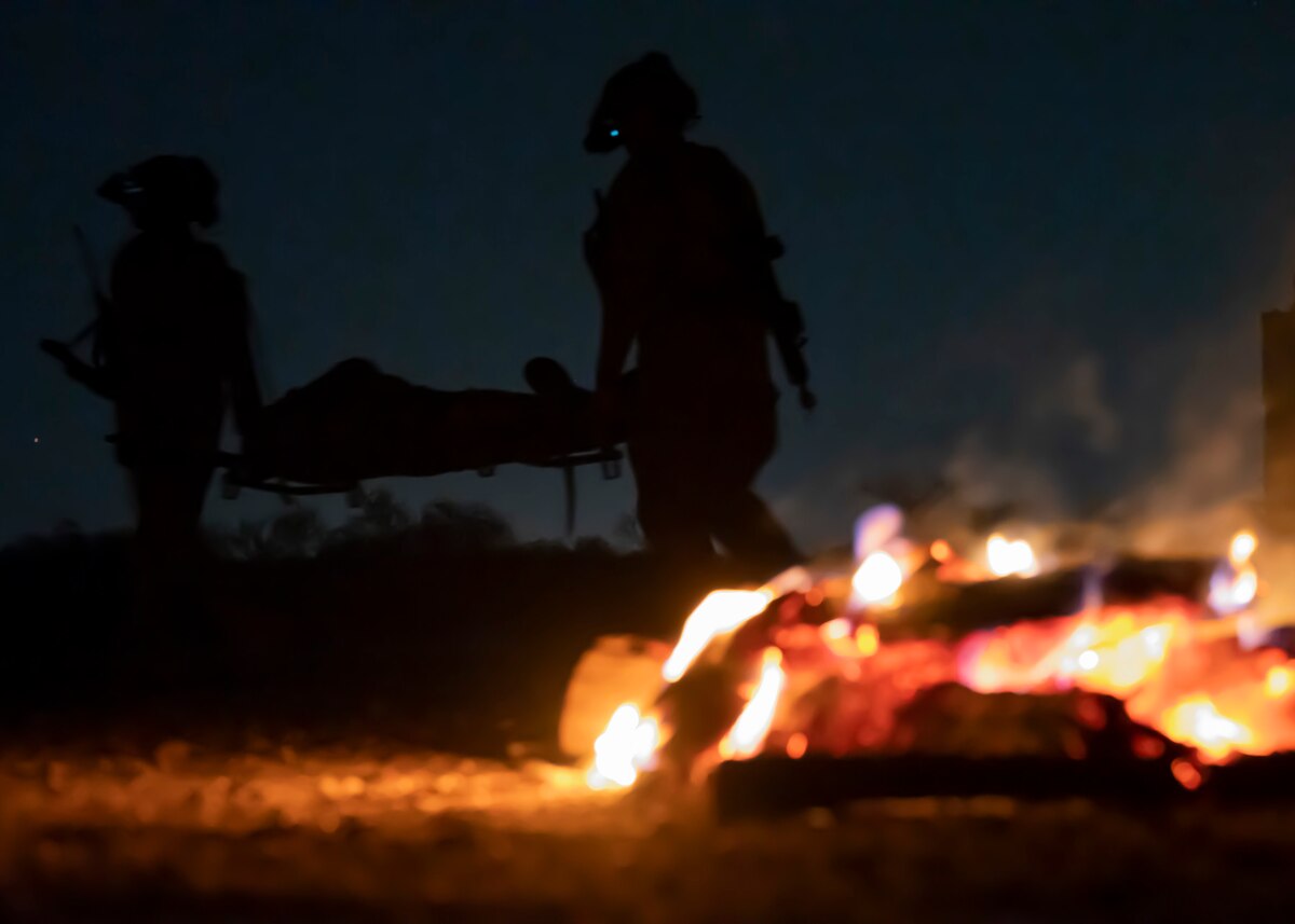 U.S. Airmen, training with the 68th Rescue Squadron, carry a simulated casualty to safety at Davis-Monthan Air Force Base, Ariz., Aug. 23, 2023. The Airmen took part in a mass casualty training exercise where they were required to treat and rescue casualties as well as engage with opposing forces. (U.S. Air Force photo by Airman 1st Class William Finn V)