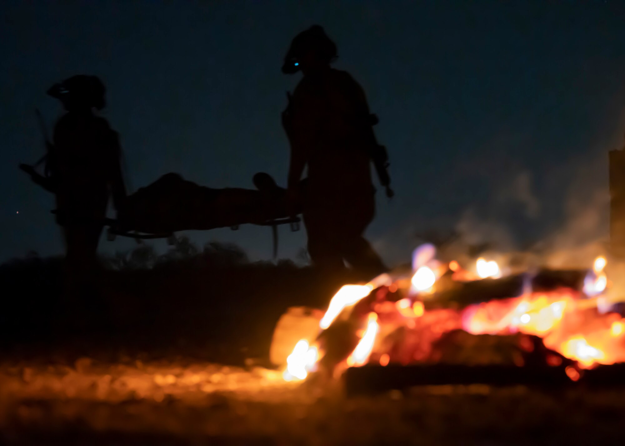 U.S. Airmen, training with the 68th Rescue Squadron, carry a simulated casualty to safety at Davis-Monthan Air Force Base, Ariz., Aug. 23, 2023. The Airmen took part in a mass casualty training exercise where they were required to treat and rescue casualties as well as engage with opposing forces. (U.S. Air Force photo by Airman 1st Class William Finn V)